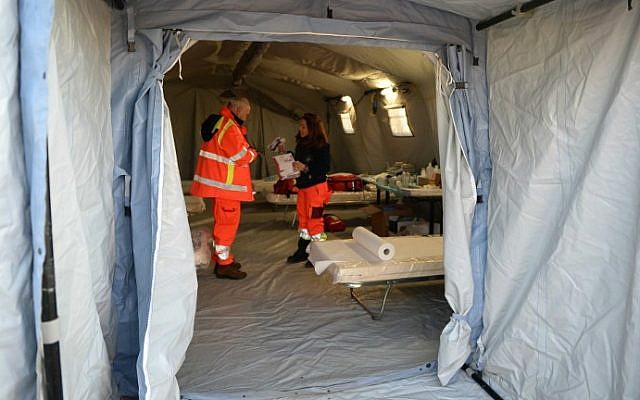 Italian Red Cross volunteers set up a tents to accommodate some 500 Syrian would-be immigrants rescued from the Ezadeen ship, on January 2, 2015 (photo credit: AFP/Alfonso Di Vincenzo) Italian Red Cross volunteers set up a tents to accommodate some 500 Syrian would-be immigrants rescued from the Ezadeen ship, on January 2, 2015 (photo credit: AFP/Alfonso Di Vincenzo)