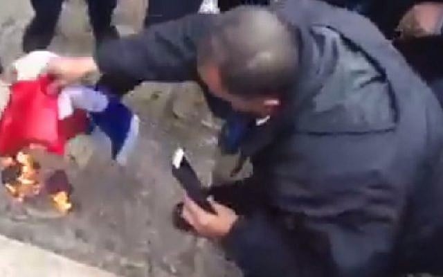 Demonstrators burn the French flag on the Temple Mount on January 16, 2015 after Friday prayers at the al-Aqsa Mosque in Jerusalem to  protest the depiction of the Prophet Muhammad in the French publication Charlie Hebdo this week. (screen capture: Shehab News Agency/Facebook)