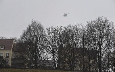 A helicopter flies over Dammartin-en-Goele, where shots were fired and at least one hostage was taken in the same area where police were hunting for the two brothers accused of slaughtering 12 people in an Islamist assault, on January 9, 2015. (photo credit: AFP/Dominique Faget)