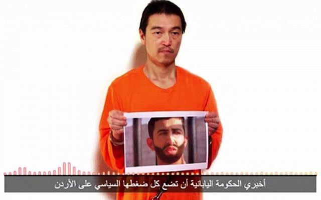 Japanese journalist Kenji Goto in a YouTube video posted by the Islamic State holding what appears to be a photo of Jordanian pilot 1st Lt. Mu'ath al-Kaseasbeh. The still image was dubbed with audio condemning Jordan for not releasing terrorst Sajida al-Rishawi and saying that unless she is freed within 24 hours, both will be killed. The Arabic subtitle reads "I only have 24 hours left to live." (Photo credit: screen capture)