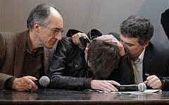 The new chief editor of French satirical magazine Charlie Hebdo, Gerard Biard, left, and columnist Patrick Pelloux, right, comfort cartoonist Luz during a press conference in Paris, France, Tuesday, Jan. 13, 2015. (AP Photo/Christophe Ena)