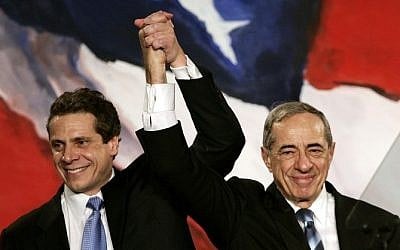 (FILES): This November 7, 2006 file photo shows then New York Attorney General Elect Andrew Cuomo (L) joining hands with his father, former New York Governor Mario Cuomo (R), during a rally held by New York Democrats in New York. (photo credit: AFP PHOTO / Files / Timothy A. CLARY) In this November 7, 2006 file photo, then New York Attorney General Elect Andrew Cuomo (L) joins hands with his father, former New York Governor Mario Cuomo, during a rally held by New York Democrats. (photo credit: AFP PHOTO / Files / Timothy A. Clary)