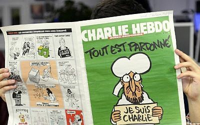 A man reads, in a newsroom in Paris, the latest issue of French satirical weekly Charlie Hebdo on January 13, 2015 (photo credit: AFP/Bertrand Guay)