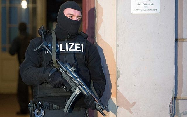 Illustrative: A member of a police task force stands in front of an apartment building where raids took place against suspected jihadists on January 16, 2015 in Berlin (photo credit: AFP/ LUKAS SCHULZE) Illustrative: A member of a police task force stands in front of an apartment building where raids took place against suspected jihadists on January 16, 2015 in Berlin (photo credit: AFP/ LUKAS SCHULZE)