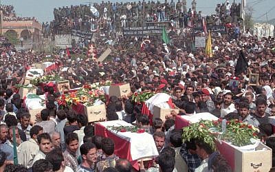 Mourners carry coffins draped in Lebanese flags as they arrive in the southern Lebanese village of Qana Tuesday, April 30, 1996 to bury 91 victims in a mass grave beside the UN post in which they were killed by Israeli shells on April 18. (photo credit: AP Photo/Ali Mohamed)