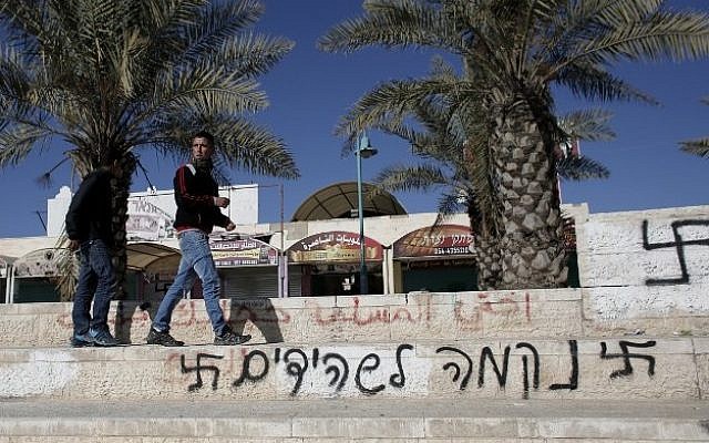 Graffiti reading in Hebrew: " Revenge for the shahids (martyrs)" flanked by two swastikas, is pictured on a wall in the southern Israeli Bedouin city of Rahat on January 20 2015. (Photo credit: AFP / AHMAD GHARABLI) Graffiti reading in Hebrew: " Revenge for the shahids (martyrs)" flanked by two swastikas, is pictured on a wall in the southern Israeli Bedouin city of Rahat on January 20 2015. (Photo credit: AFP / AHMAD GHARABLI)