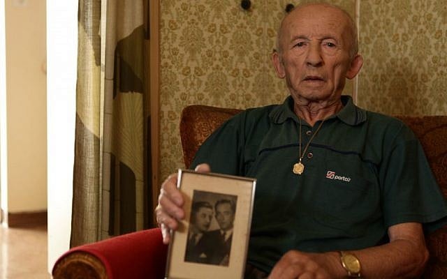 Stefan Weiss, with a photograph of his family, in his room at Reuth. (Eldad Rafaeli)
