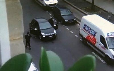 In this image from an amateur video recorded on January 7, 2015, masked gunmen get into a car moments after shooting a police officer outside the offices of French satirical newspaper Charlie Hebdo in Paris. (photo credit: AP/Jordi Mir) 