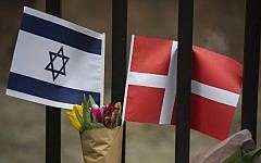 A Danish and an Israeli flag seen among flowers and candles honoring the victims of a shooting attack outside the main synagogue in Copenhagen, Denmark on February 15, 2015. (AFP/Odd Andersen)