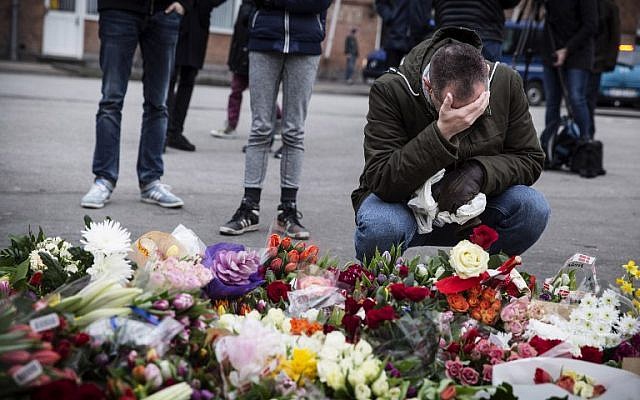 A man kneels next to flowers laid in honor of the shooting victims outside the Kruttoende cultural center in Copenhagen, Denmark on February 15, 2015. (photo credit: AFP PHOTO / CLAUS BJORN LARSEN) A man kneels next to flowers laid in honor of the shooting victims outside the Kruttoende cultural center in Copenhagen, Denmark on February 15, 2015. (photo credit: AFP PHOTO / CLAUS BJORN LARSEN)