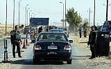 Illustrative: Egyptian police inspect cars at a checkpoint in North Sinai on January 31, 2015. (photo credit: AFP PHOTO / STR)