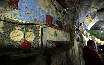 Syrian national Jihad al-Mohamed stands in an abandoned synagogue where has has been living in Lebanon's southern city of Sidon on Feb. 8, 2015. Five destitute Syrian and Palestinian families have taken up residence in the synagogue and  few signs remain to indicate that the building was once a Jewish house of worship. (Photo credit: Joseph Eid/AFP)