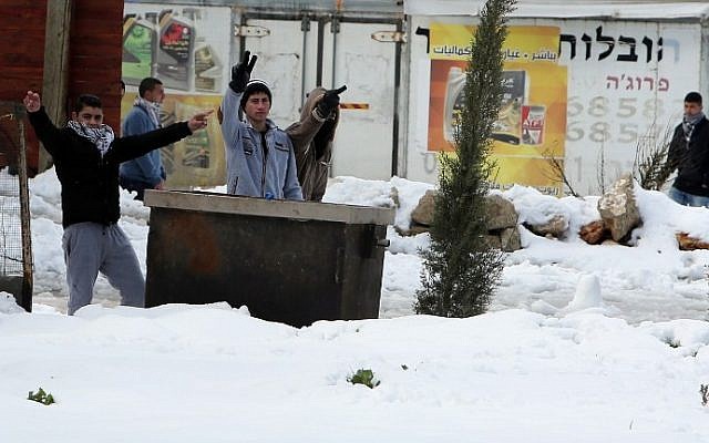 Palestinian youths from the Jalazoun refugee camp gesture towards Israeli security forces (unseen) during clashes in the West Bank on February 20, 2015. (photo credit: AFP/Abbas Momani)
