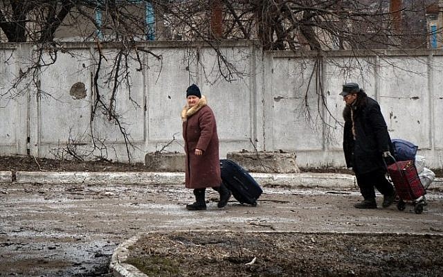 People walk with their belongings in the eastern Ukrainian town of Vuglegirsk in the Donetsk region, February 7, 2015. (photo credit: AFP/ANDREY BORODULIN) People walk with their belongings in the eastern Ukrainian town of Vuglegirsk in the Donetsk region, February 7, 2015. (photo credit: AFP/ANDREY BORODULIN)