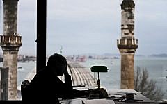 Turkish Nobel laureate author Orhan Pamuk works at his desk at his house in Istanbul, on Febuary 2, 2015. (photo credit: AFP/OZAN KOSE)