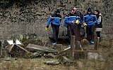 Illustrative: French gendarmes investigate in the area of defaced tombstones at the Jewish cemetery of Sarre-Union, northeastern France, on February 16, 2015. (AFP/Frederick Florin/ File)
