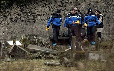 Illustrative: French gendarmes investigate in the area of defaced tombstones at the Jewish cemetery of Sarre-Union, northeastern France, on February 16, 2015. (AFP/Frederick Florin/ File)