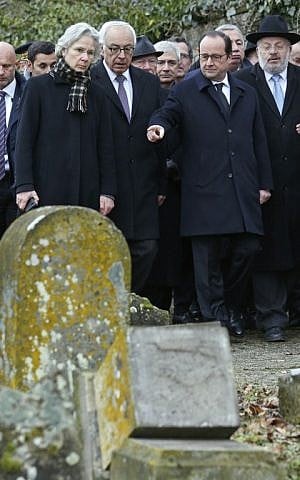French President Francois Hollande (2ndR), Israeli ambassador to France Yossi Gal (C), and Strasbourg and Bas-Rhin Grand Rabbi Rene Gutman (R) look at desecrated tombstones during a ceremony at Sarre-Union's Jewish ceremony, eastern France, on February 17, 2015, following the desecration of around 300 tombs. (Photo credit: AFP/POOL/VINCENT KESSLER)
