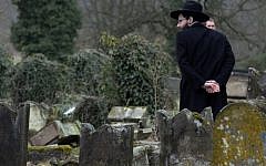 A member of the Jewish community looks at broken tombstones after a ceremony at the Jewish cemetery in Sarre-Union, eastern France, on February 17, 2015, following the desecration of around 300 tombs. (Photo credit: AFP/PATRICK HERTZOG)