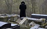 A member of the Jewish community looks at broken tombstones after a ceremony at the Jewish cemetery in Sarre-Union, eastern France, on February 17, 2015, following the desecration of around 300 tombs. (AFP/Patrick Hertzog)