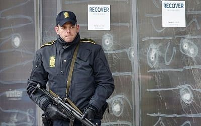 A police officer stands in front of the cultural center in Copenhagen, Denmark, on February 16, 2015, after a shooter killed one person. (photo credit: AP/Michael Probst)