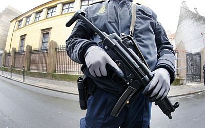 A Danish police officer stands outside the synagogue where a gunman opened fire in Copenhagen, Denmark, on February 15, 2015. (photo credit: AP/Michael Probst)