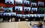 A shopper stands in front of televisions broadcasting a speech by Prime Minister Benjamin Netanyahu at an electronics shop in Jerusalem. (Abir Sultan/Flash90)