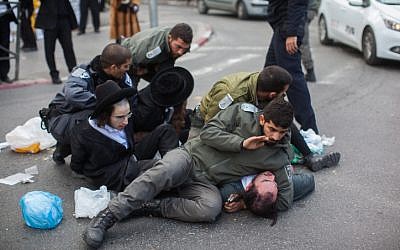 Police officers clash with ultra-Orthodox men during a protest against the jailing of Jewish seminary students who failed to comply with a recruitment order, in Jerusalem's Mea Shearim neighborhood on February 8, 2015. (photo credit: Yonatan Sindel/Flash90)
