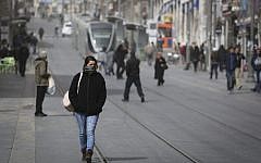 Israelis walk in Jerusalem as a dust storm hit the city on February 11, 2015. (Photo credit: Hadas Parush/Flash90)