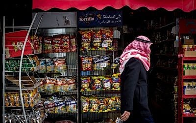 A Palestinian man walks by a store that stacks Israeli snacks in Bethlehem, on February 11, 2015. (photo credit: Miriam Alster/Flash 90)