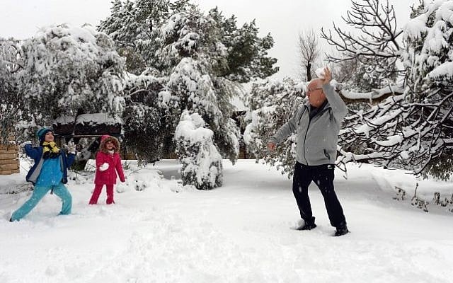 President Reuven Rivlin plays with his grandchildren in his snow-covered garden at the President's Residence in Jerusalem after a snow storm hit the capital, February 20, 2015 (Photo credit: Haim Zach/GPO)