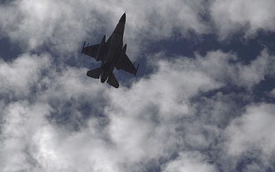 A Jordanian Air Force fighter jet flies over the village of Ai as Jordanian King Abdullah II visits to offer his condolences to the tribe of the slain Jordanian pilot, Lt. Mu'ath al-Kaseasbeh at their home village near Karak, Jordan, Thursday, Feb. 5, 2015. (photo credit: AP Photo/Nasser Nasser)