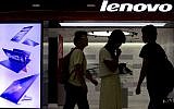 In this Aug. 15, 2013 file photo, people walk past a Lenovo flagship experience store in Beijing, China. (photo credit: AP/Andy Wong, File)