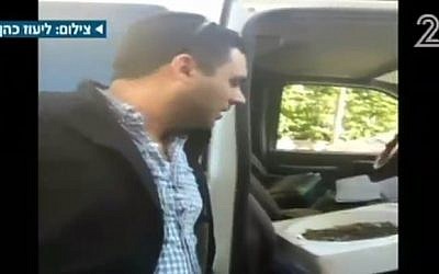 A parking ticket collector looks at a tub of coins, after a man chooses to pay his $200 ticket in coins to get back at police (screen capture: Channel 2)