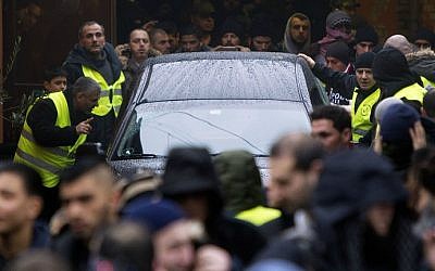Mourners surround the hearse with late Omar Abdel Hamid El-Hussein leaving the Mosque on Dortheavej in Copenhagen driving to the Muslim cemetery in Broendby south of Copenhagen on February 20 2015. (photo credit: AFP/Scanpix Denmark/Nils Meilvang)