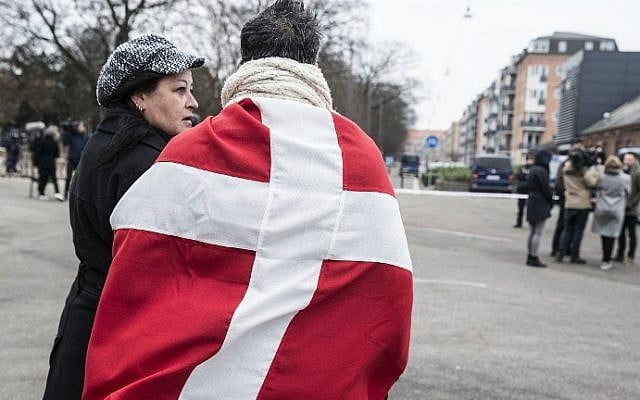 A woman and a man wearing the danish flag stand outside the main Synagogue in Copenhagen on February 15, 2015 following two fatal attacks in the Danish capital, a month after the Paris attacks. (photo credit: AFP/Claus Bjorn Larsen) A woman and a man wearing the danish flag stand outside the main Synagogue in Copenhagen on February 15, 2015 following two fatal attacks in the Danish capital, a month after the Paris attacks. (photo credit: AFP/Claus Bjorn Larsen)
