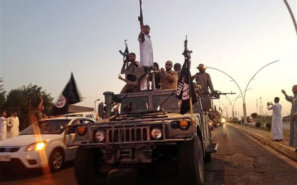 Fighters from the Islamic State group parade in a commandeered Iraqi security forces armored vehicle down a main road in Mosul, Iraq, on June 23, 2014. (photo credit: AP/File)