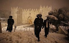 Ultra-Orthodox Jewish men walk near Damascus Gate in Jerusalem’s Old City as snow falls on February 19, 2015. (AFP/Ahmad Gharabli)