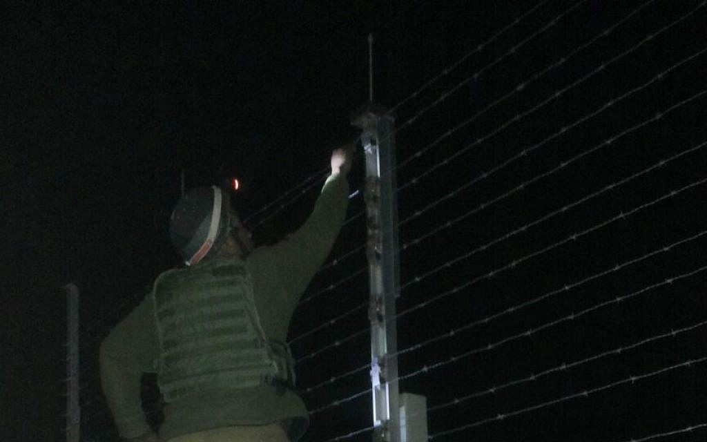 A Kometz soldier, standing on a ladder on the Gaza side of the barrier, fixing the fence (photo credit: Netta Asner/IDF Spokesperson's Unit) A Kometz soldier, standing on a ladder on the Gaza side of the barrier, fixing the fence (photo credit: Netta Asner/IDF Spokesperson's Unit)