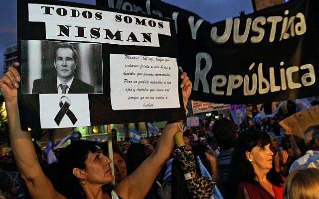 A woman holds a signs with prosecutor Alberto Nisman's portrait in Rosario, Argentina on February 18, 2015, during a march simultaneous to the "Marcha del silencio" (March of Silence) called by Argentine prosecutors in memory of their late colleague Nisman in Buenos Aires. (photo credit: AFP/NA - Agencia Cordoba)