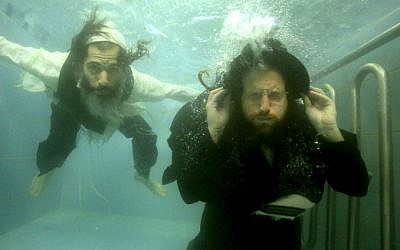 This undated photo provided by Channel 8 and Go2Films shows Ori Gruder, left, and rabbi Yisrael Aharon Itzkovitz swimming in their clothes in a ritual bath, which is created for publicity purpose for "Sacred Sperm," a film Gruder directed. (photo credit: AP Photo/Gliad Kavalerchik)