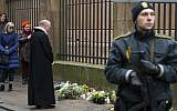 The Dean of Copenhagen Cathedral Anders Gadegaard (second from the right) and his congregation offer prayers for the shooting victims outside the synagogue Krystalgade in Copenhagen, on February 15, 2015 after two fatal attacks in the Danish capital, at a cultural center during a debate on Islam and free speech and a second outside the city's main synagogue. (AFP/Odd Andersen)