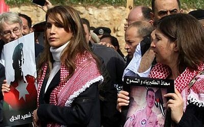 Jordan's Queen Rania holds a picture of slain Jordanian pilot, Lt. Muath al-Kaseasbeh, during a march after Friday prayers in Amman, Jordan, Friday, Feb. 6, 2015 (photo credit: AP/Raad Adayleh)