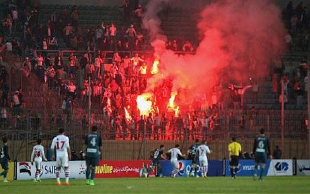 Soccer fans hold lit flares at the stand as they watch a match between Egyptian Premier League clubs Zamalek and ENPPI at Air Defense Stadium in a suburb east of Cairo, Egypt, Sunday, February 8, 2015 (photo credit: AP/Ahmed Abd El-Gwad, El Shorouk newspaper) Soccer fans hold lit flares at the stand as they watch a match between Egyptian Premier League clubs Zamalek and ENPPI at Air Defense Stadium in a suburb east of Cairo, Egypt, Sunday, February 8, 2015 (photo credit: AP/Ahmed Abd El-Gwad, El Shorouk newspaper)