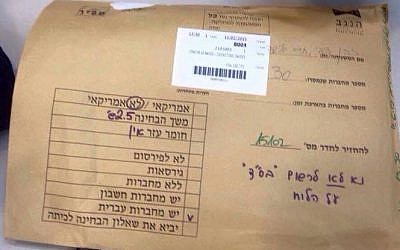 An envelope containing exams, on top of which were written orders not to write BS"D on the classroom board. (photo credit: Facebook screen capture)