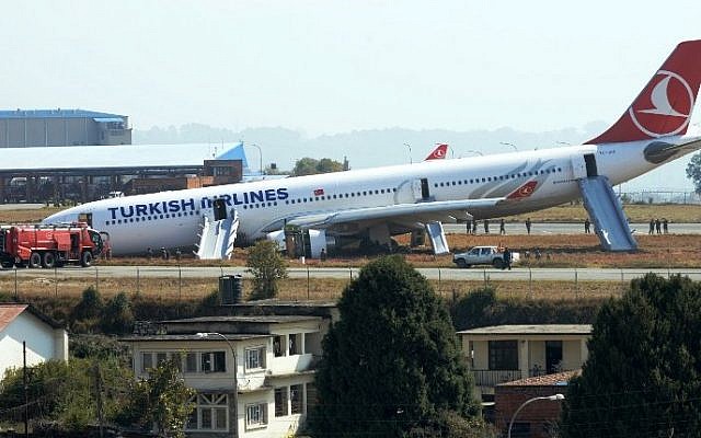 Nepalese rescue workers check the area around a Turkish Airlines aircraft after it slid off the tarmac on landing at Kathmandu's international airport on March 4, 2015. (photo credit: AFP / PRAKASH MATHEMA) Nepalese rescue workers check the area around a Turkish Airlines aircraft after it slid off the tarmac on landing at Kathmandu's international airport on March 4, 2015. (photo credit: AFP / PRAKASH MATHEMA)
