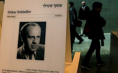 Visitors walk past a portrait of Oskar Schindler at the Yad Vashem Holocaust memorial museum in Jerusalem, on March 4, 2015. (photo credit: AFP / GALI TIBBON)