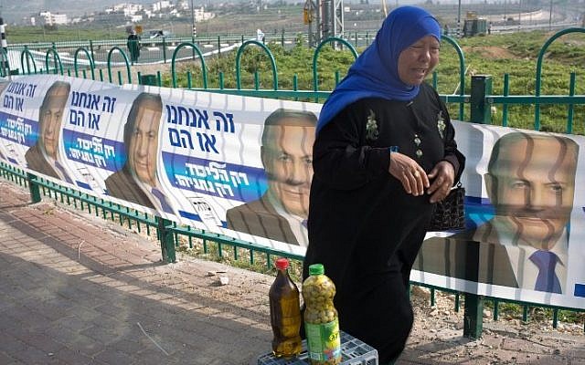 A Palestinian street vendor sells olive oil in front of campaign posters for Benjamin Netanyahu's Likud party on March 10, 201, in Givat Zeev, a West Bank settlement north of Jerusalem. (AFP/MENAHEM KAHANA) A Palestinian street vendor sells olive oil in front of campaign posters for Benjamin Netanyahu's Likud party on March 10, 201, in Givat Zeev, a West Bank settlement north of Jerusalem. (AFP/MENAHEM KAHANA)