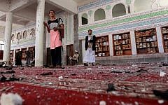 Yemeni armed men inspect the damage following a bomb explosion at the Badr mosque in southern Sanaa on March 20, 2015. (Photo credit: AFP/ MOHAMMED HUWAIS)