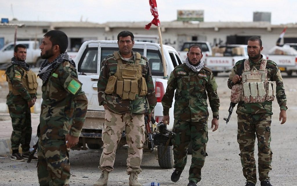 Iraqi Sunni fighters stand on March 22, 2015 at a checkpoint at the entrance of Al-Alam, a flashpoint town north of Tikrit along the Tigris river. (photo credit: Ahmad al-Rubaye/AFP)